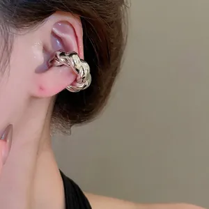 Manchette d'oreille argentée torsadée au fini poli brillant portée sur l'oreille
