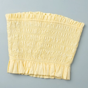 Detailed view of smocked light yellow tube top with elasticated ruffled edges and texture