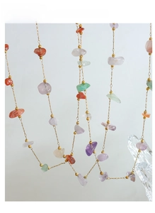Detailed view of colorful natural stone necklace with irregular gems and gold-plated chain
