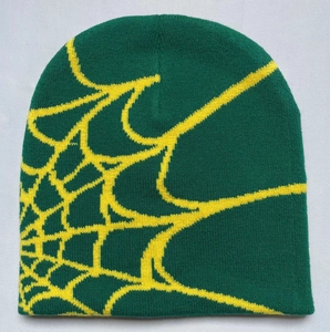Detailed knit texture and yellow spider web pattern on a dark green beanie