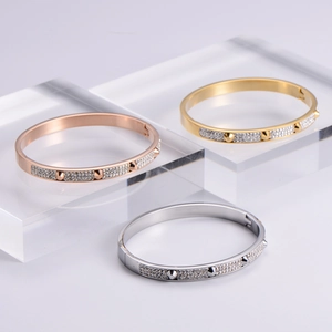 Set of three nail bracelets in rose gold, gold, and silver with pave diamonds and studs