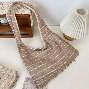 Close-up of bohemian crochet tote with shell tassels and colorful wavy knit patterns