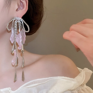 Detail of silver bow tassel earrings with pink flower petals and sparkling crystals