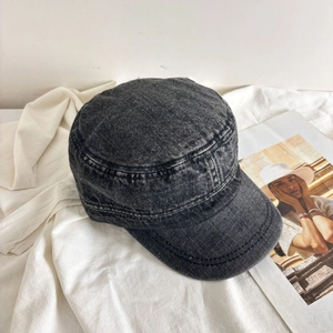Detail of vintage washed grey denim military cap with contrast stitching and soft brim texture