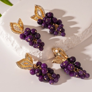 Boucles d'oreilles raisin avec perles mauves, feuilles dorées et strass en vue de dessus