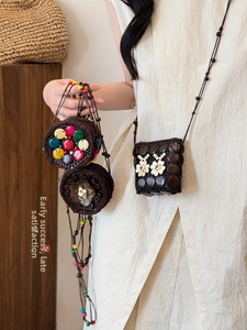 Detail of bohemian handmade coconut shell crossbody bag with ethnic beaded flower accents