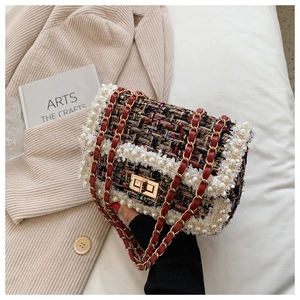 Detail of tweed crossbody bag with white pearl trim and golden metal square lock