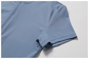 Close-up of the front zipper closure and flat seam stitching on a blue yoga bodysuit