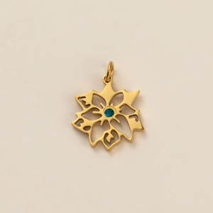Détail macro du pendentif flocon doré avec une pierre précieuse bleue étincelante