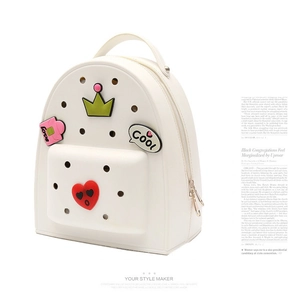 Detail of white EVA backpack featuring perforated surface with colorful DIY charms