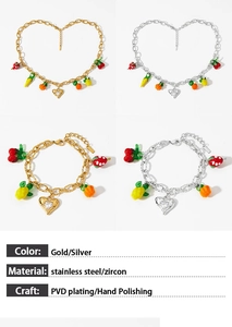 Macro view of gold and silver fruit charms with zircon on stainless steel jewelry