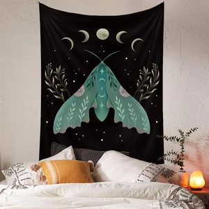 Bohemian black wall tapestry with green lunar moth and moon phases in a cozy bedroom decor