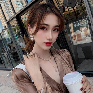 Outdoor shot of stylish pearl rabbit ear earrings, star necklace and butterfly ring on model