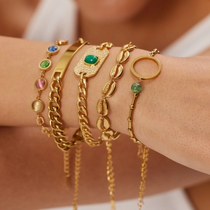Set di cinque bracciali a catena dorati con pietre preziose verdi e ciondoli a conchiglia