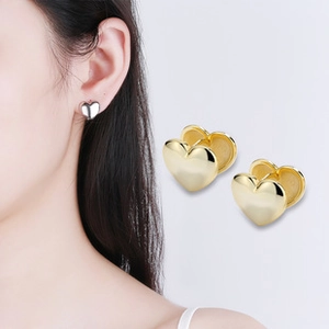 Vue détaillée et mannequin portant des boucles d'oreilles polies en forme de cœur
