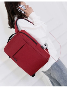Detail of red business laptop backpack with integrated USB charging port and cable