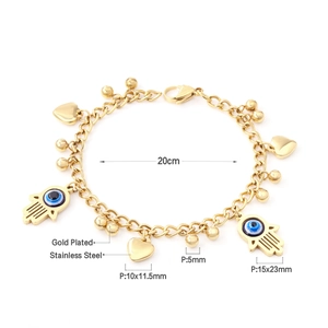 Detail of gold plated stainless steel Hamsa Hand and Evil Eye charms on beaded bracelet