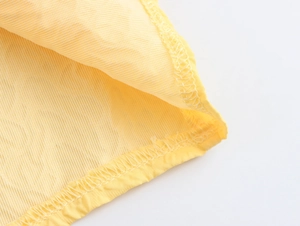 Close-up of yellow embossed bubble textured fabric with professional seam stitching detail