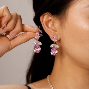 Gros plan sur les boucles d'oreilles poire roses avec base dorée et oxydes de zirconium