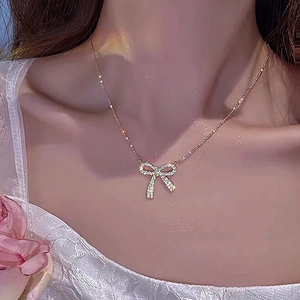 Exquisite golden bowknot zircon necklace worn by a model with elegant lace details