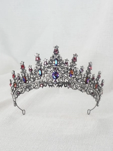 Close-up of vintage princess crown with purple water-drop gems and colorful crystals