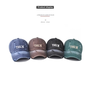 Row of washed denim baseball caps with THINK embroidery in blue, brown, black and green