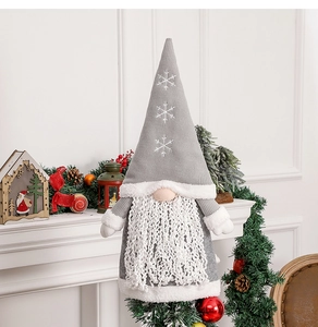 Gnome plush with knitted snowflake hat displayed on a mantel with festive pine and cones