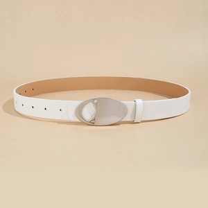 Detail of white leather belt with silver oval buckle coiled on a beige background