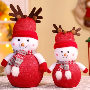 Detail of two plush Christmas snowmen with red knit hats and festive sequin fabric texture