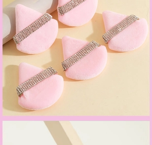 Macro detail of five pink velvet triangular powder puffs with rhinestone ribbon accents