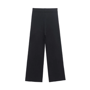 Dettaglio dei pantaloni neri in maglia a costine a gamba larga con trama verticale