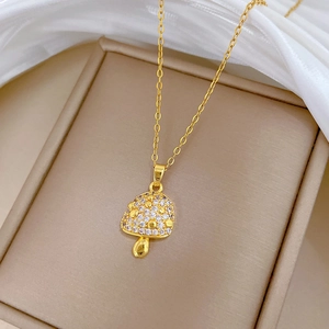 Elegant gold mushroom pendant necklace with sparkling pavé cubic zirconia on beige stand
