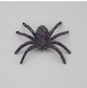 Macro shot of a colorful glitter-coated plastic spider for Halloween scene decoration