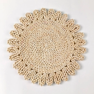 Detailed macro view of handcrafted circular corn husk placemat with floral weaving texture
