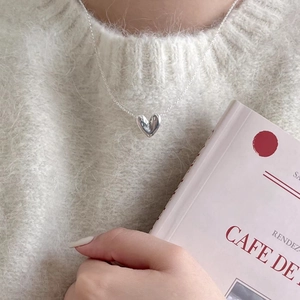 Minimalist 925 sterling silver heart necklace worn on a soft knit sweater