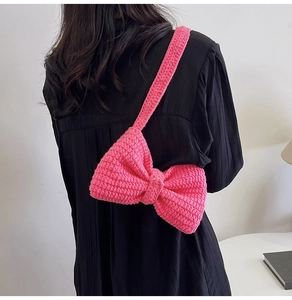 Détail du sac à bandoulière en tricot rose vif en forme de nœud papillon 3D