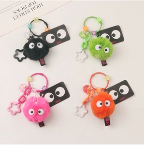 Macro detail of colorful plush soot sprite keychains with big eyes and star accessories