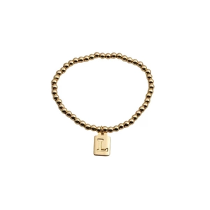 Bracelet à perles dorées avec un charm carré en métal et gravure de la lettre L