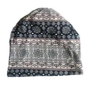 Detail of ethnic paisley print on navy jersey beanie with heart pattern and wavy edges