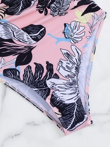 Detail of pink tropical palm leaf swimsuit fabric with precise double-needle stitching