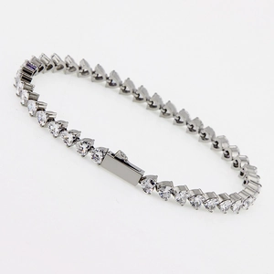 Dettaglio macro del bracciale tennis in acciaio lucido con zirconi a forma di cuore