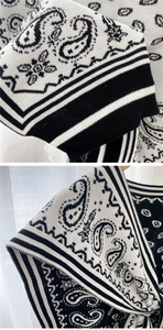 Detailed knit texture of paisley and stripe pattern scarf with refined black and white edges