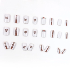 Nail art set with white and brown heart patterns, silver glitter and rhinestone details