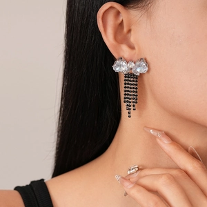Detailed close-up of zircon butterfly tassel earrings and ring set on model