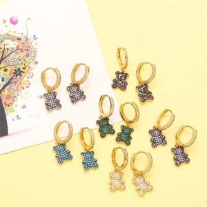 Detailed macro view of colorful bear charms on gold-plated earrings with zircon stones