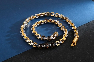 Detail of two-tone gold and silver hexagonal chain links with a secure lobster clasp