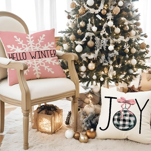 Federe per cuscini natalizi in lino rosa e bianco con scritta Hello Winter su divano