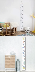 Detail of wooden canvas growth charts with rocket and rainbow themes for kids' rooms