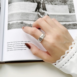 Detailed close-up of matte S925 sterling silver wide ring with irregular hammered texture