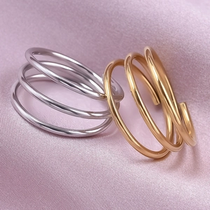 Three-layer minimalist 304 stainless steel rings in gold and silver on pink silk fabric